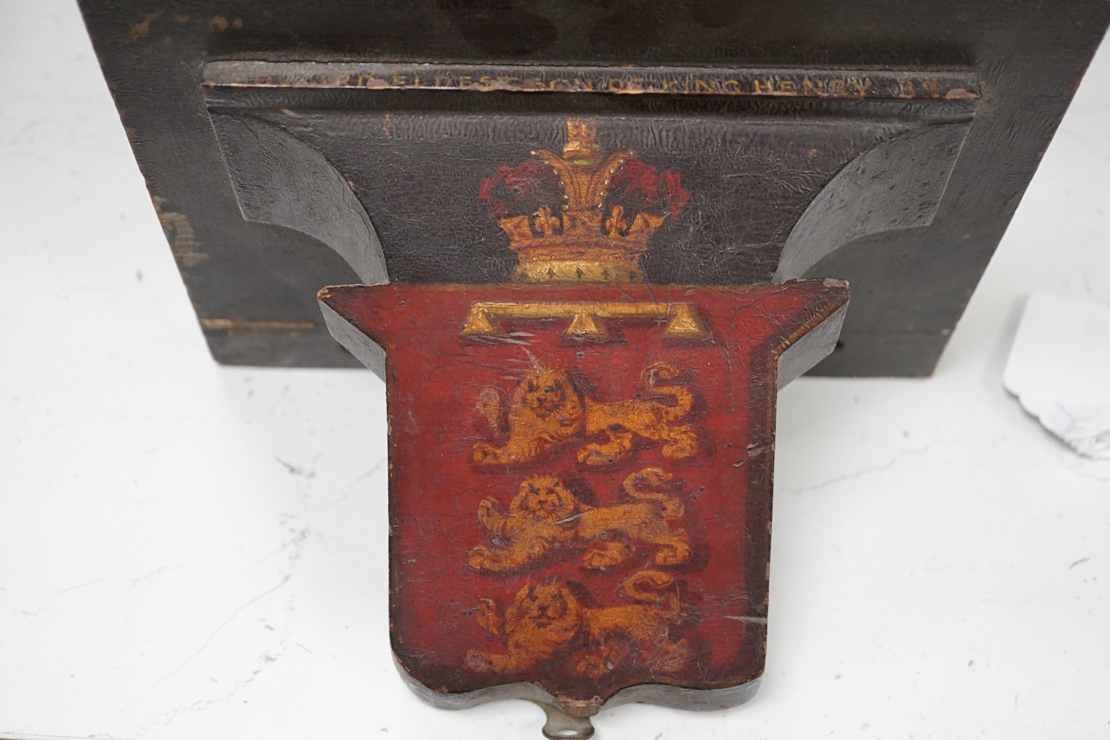 Four 19th century painted and ebonised heraldic wall brackets together with a 19th century armorial plaque